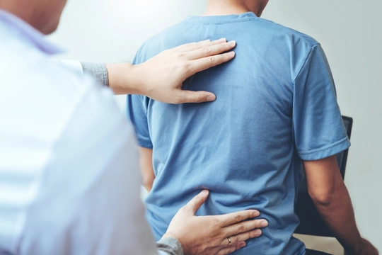 Chiropractor examining a patients back.